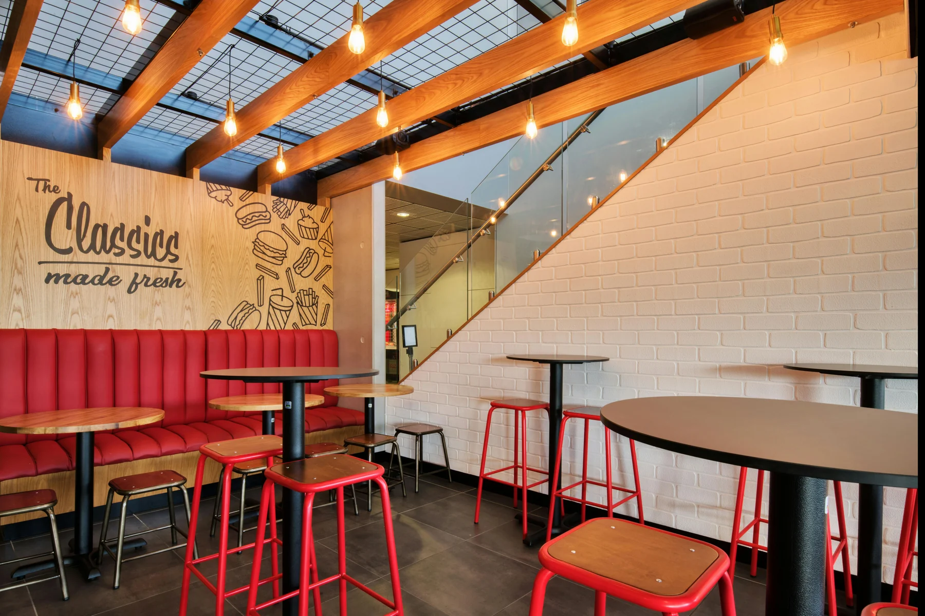 The red booths, warm timber and tiled walls inside Ruby Chews